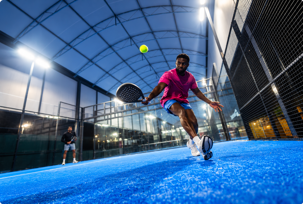 Low-angle view of a competitive padel match on an indoor court